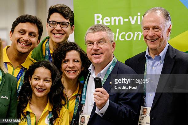 President of the International Olympic Committee Tomas Bach takes pictures with a 360-degree camera given by an official videographer as Carlos...