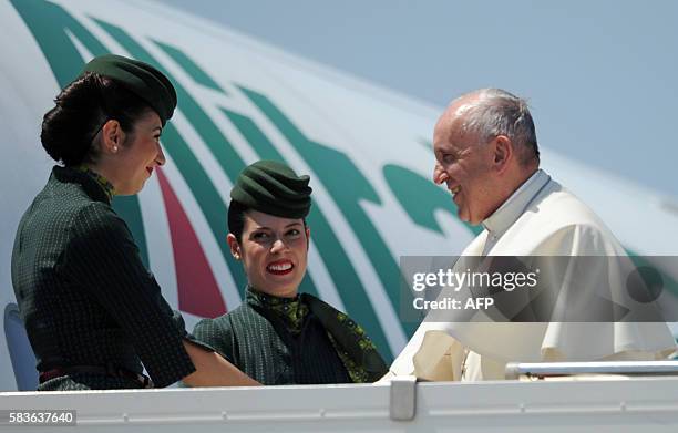 Pope Francis shakes hand with Alitalia cabin crew before boarding a plane to Poland at Rome's Fiumicino International Airport on July 27, 2016 in...