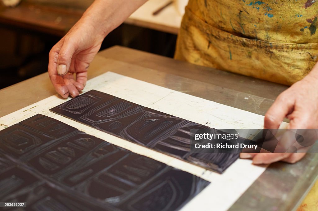 Printmaker preparing press to make lino print