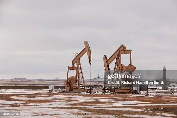 oil pumps in bakken oil field - oil well foto e immagini stock