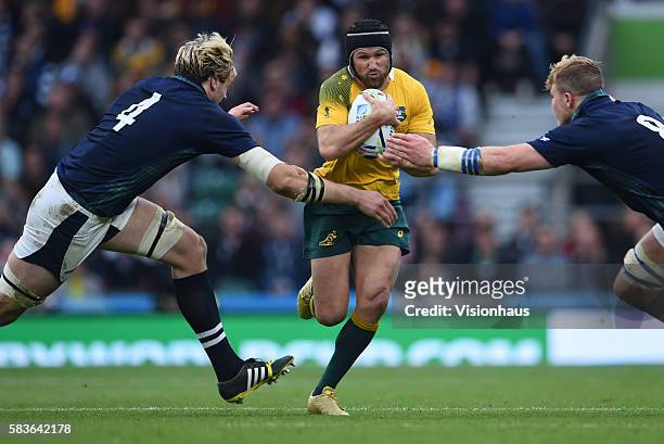 Matt Giteau of Australia is tackled by Richie Gray and David Denton of Scotland during the Rugby World Cup 2015 Quarter-Final match between Australia...