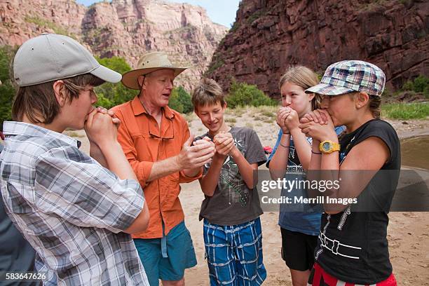 group of teenagers learning to whistle with leaf - dinosaur national monument stock-fotos und bilder
