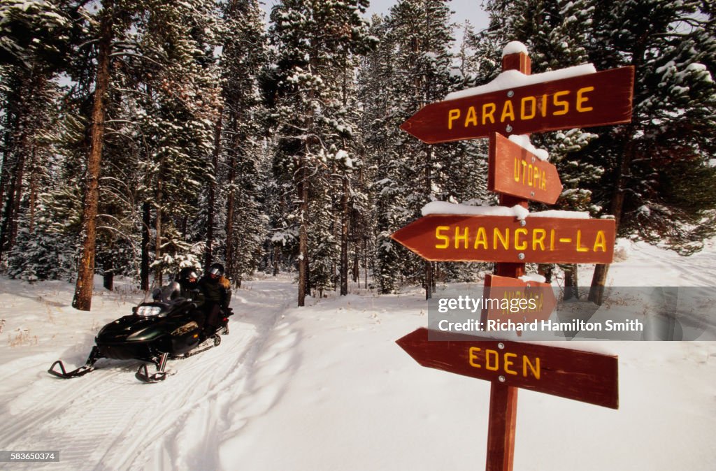Snowmobilers by Sign Post