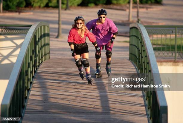 two inline skaters crossing footbridge - inline skating - fotografias e filmes do acervo