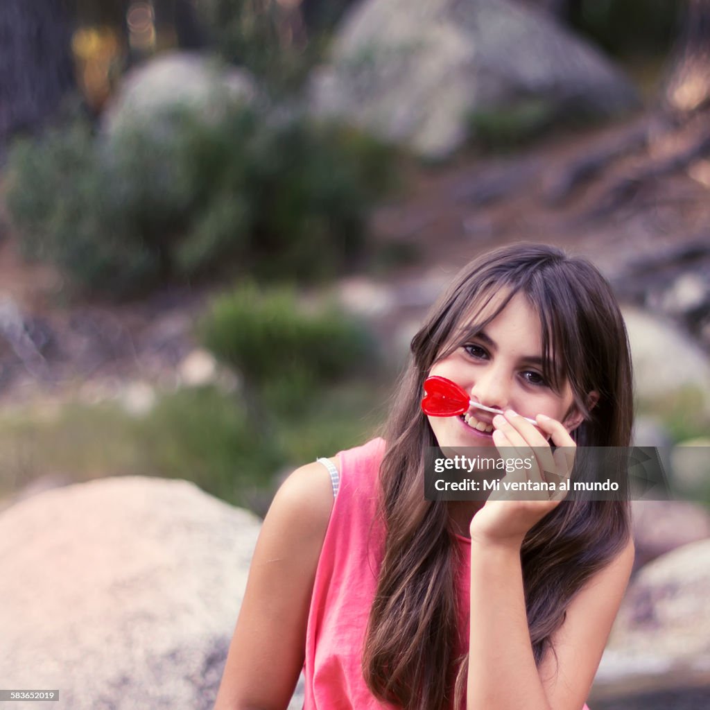 Young girl with a heart shaped lollipop