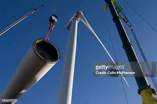 One of the last remaining 11-ton blades on a 2.5 megawatt wind turbine at Alexandra Dock in Liverpool is lifted into place by cranes. The month-long...