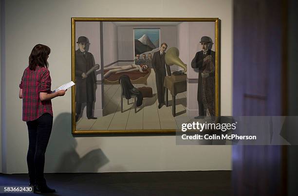 Woman looking at the painting entitled 'The Menaced Assassin ' by Rene Magritte. An exhibition of the artist's work will open at Tate Liverpool on 24...