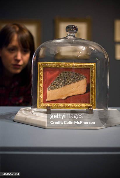 Woman looking at a painting entitled 'This Is A Piece Of Cheese ' by Rene Magritte. An exhibition of the artist's work will open at Tate Liverpool on...