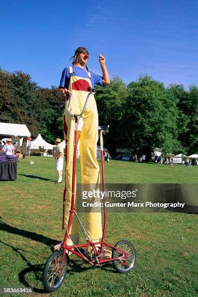 entertainer on stilts with bicycle - échasses photos et images de collection