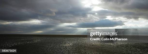 Rays of sunshine break through the clouds over the Dee Estuary which separates the Wirral peninsula in England from the north Wales coast. The area...