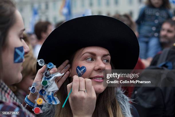 Woman having a Scottish flag painted on her face at a pro-independence gathering in George Square, Glasgow. The gathering brought together Yes...