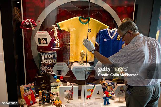 Curator putting the final touches to one of the displays featuring Maradona's 'Hand of God' shirt at the National Football Museum in Manchester...