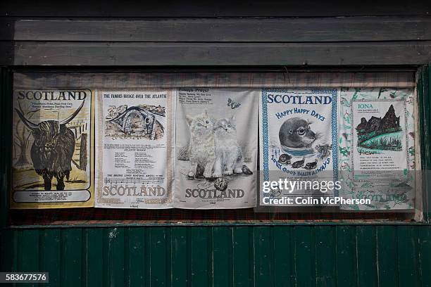 Row of Scottish-themed tea towels in a window of a shop on the island of Seil, Argyll and Bute on Scotland's west coast. On 18th September 2014,...