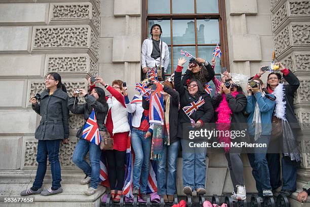 Crowd of onlookers in Whitehall, London, cheering as the newly-wed Prince William and Catherine Middleton drive from the marriage ceremony towards...