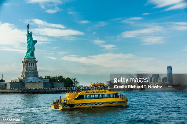 statue of liberty and tour boat and lower manhattan - táxi aquático imagens e fotografias de stock