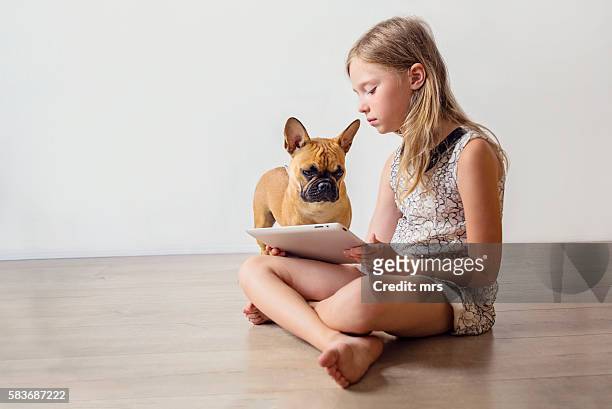 girl with dog looking at digital tablet - latvia girls stock pictures, royalty-free photos & images