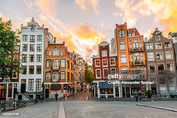 traditional dutch old houses in amsterdam at sunset, netherlands - amsterdam foto e immagini stock
