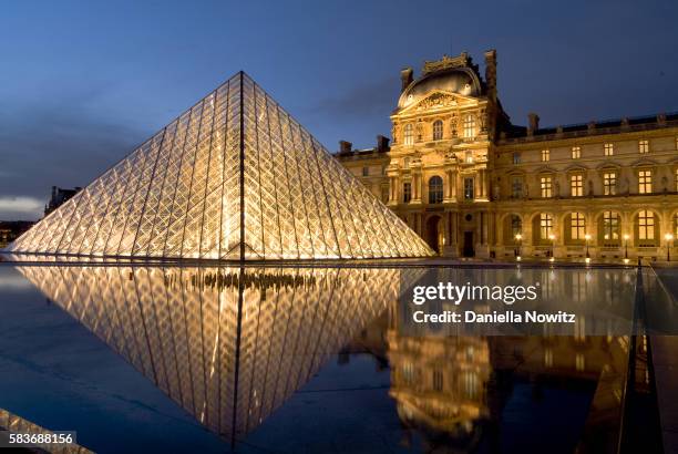 pyramid entrance to louvre reflected in pool - louvre fotografías e imágenes de stock