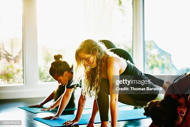 Woman in yoga class in studio in low lunge pose