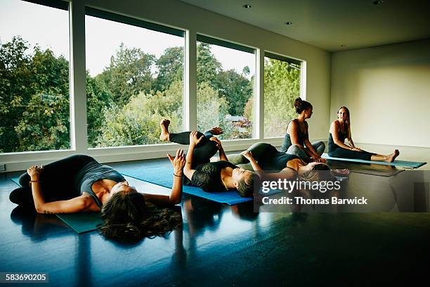 Women talking and stretching after yoga class