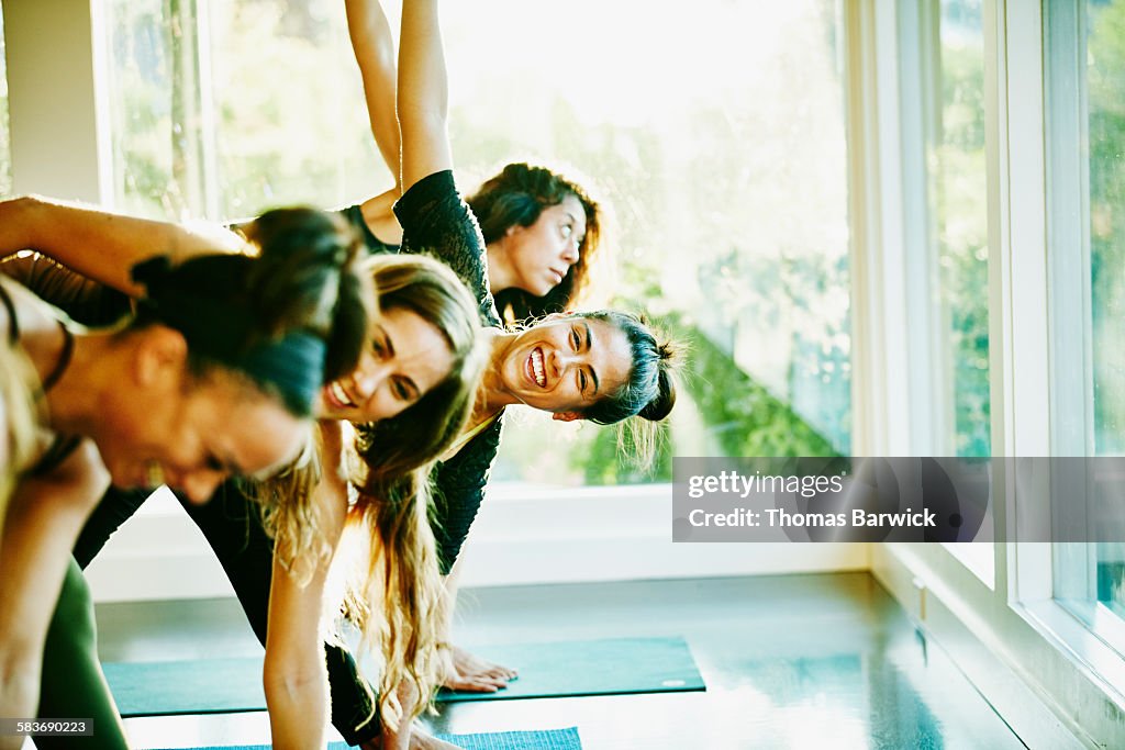 Woman laughing with friends during yoga class