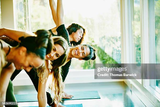 woman laughing with friends during yoga class - group exercise stock-fotos und bilder