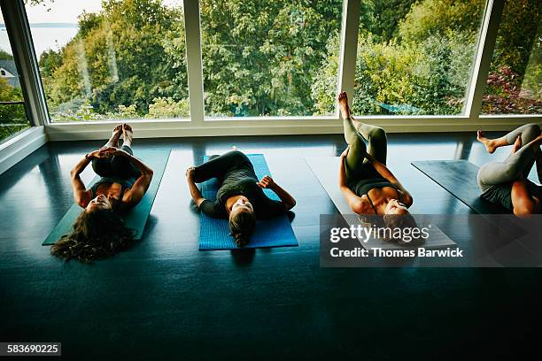 Women stretching after yoga class in  studio