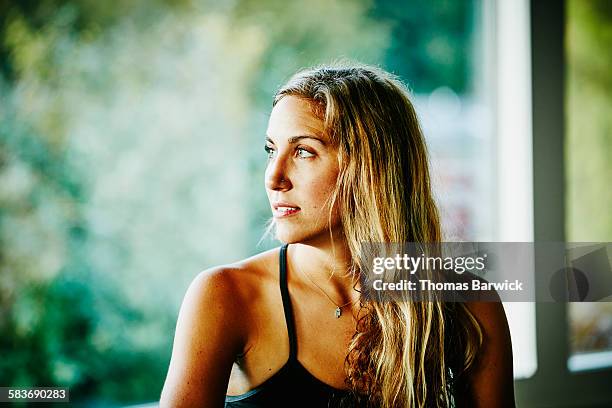 Smiling woman resting after yoga class in studio