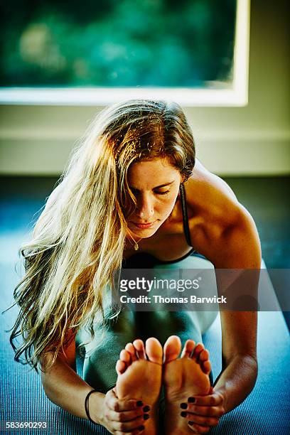 Woman in seated forward bend in yoga class