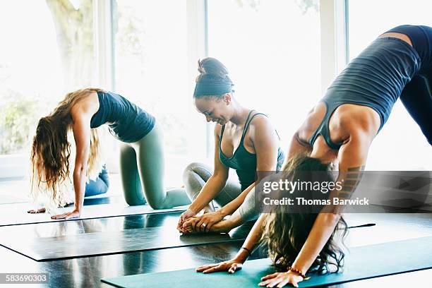 women stretching before yoga class in studio - leggings stock pictures, royalty-free photos & images