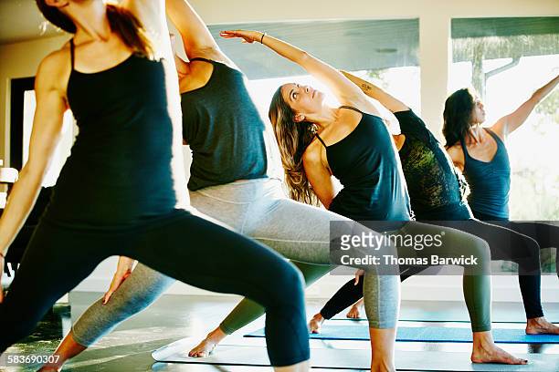 Women in reverse warrior pose during yoga class