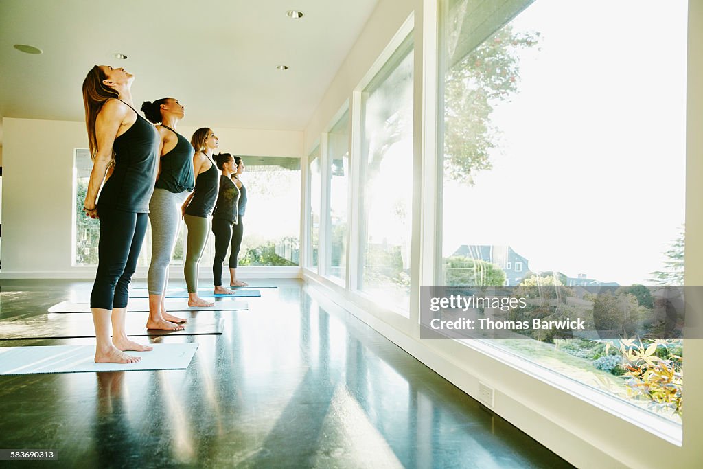 Women standing in yoga studio stretching