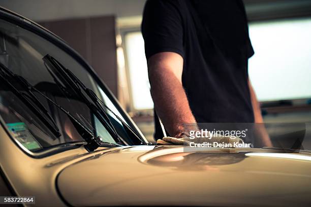 adult man polishing oldtimer car in workshop with cleaning cloth - old car garage stock pictures, royalty-free photos & images