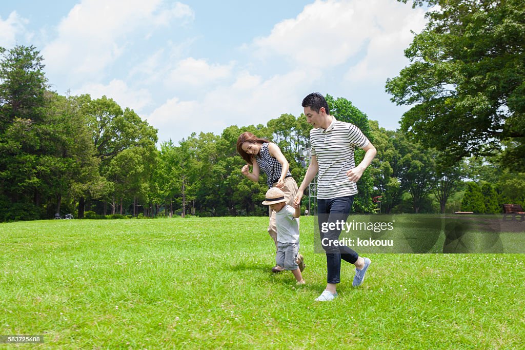 Family running hand in hand in the park
