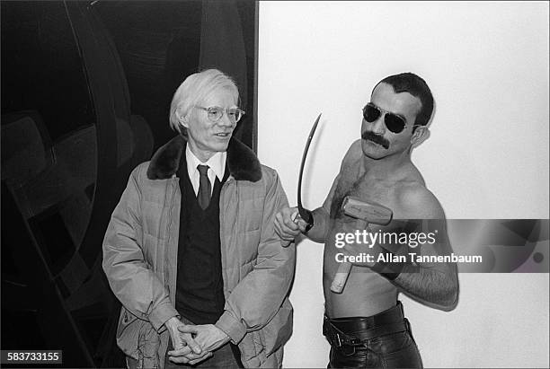 At the opening of his 'Hammer & Sickle' show at the Castelli Gallery, artist Andy Warhol poses with Victor Hugo, who holds the original hammer and...