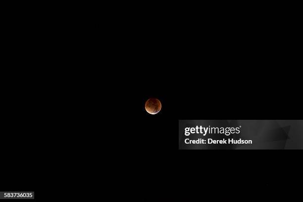 Early morning view of a total eclipse of the moon, which appears as a bright orange sphere, Berlin, Germany, September 28, 2015.