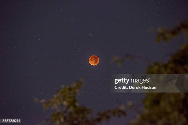 Early morning view of a total eclipse of the moon, which appears as a bright orange sphere, Berlin, Germany, September 28, 2015.