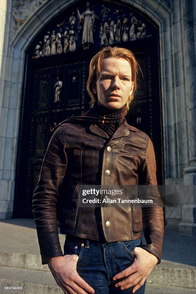 Portrait of American poet, author, and musician Jim Carroll stands in