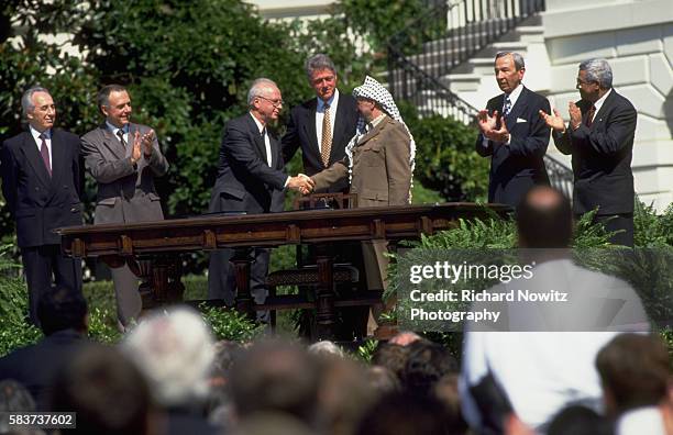 Yitzak Rabin of Israel and Yassir Arafat shake hands after signing the peace accord between Israel and the Palestine Liberation Organization at the...