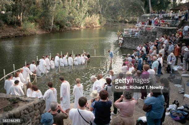 pilgrims baptised in jordan river - river jordan stock pictures, royalty-free photos & images