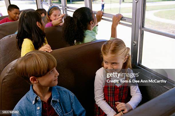 children riding school bus - kids sitting together in bus stock pictures, royalty-free photos & images