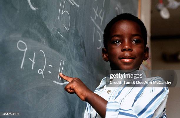 student solving a math problem at the chalkboard - boy giving speech stock pictures, royalty-free photos & images