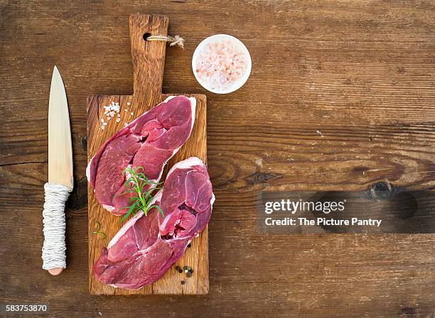 raw fresh meat lamb entrecote and seasonings on cutting board over rustic wooden background. - entrecôte stock pictures, royalty-free photos & images