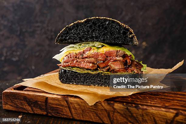 cut in half roast beef burger with sliced pastrami on dark background - half and half stock pictures, royalty-free photos & images