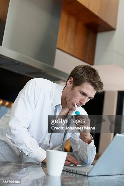 businessman using laptop computer in kitchen - business mann laptop stock pictures, royalty-free photos & images