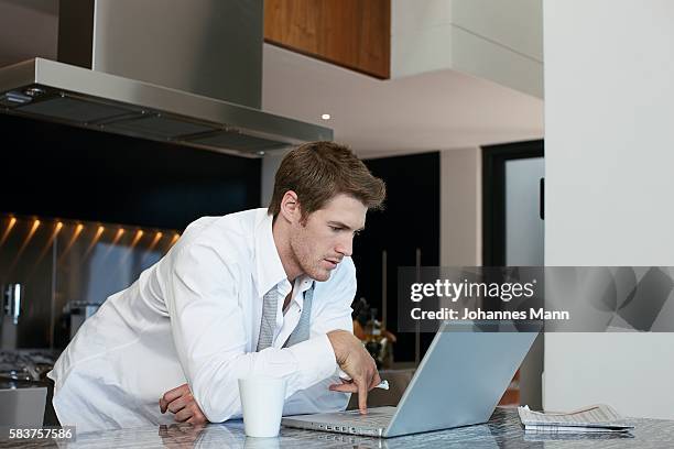 businessman using laptop computer in kitchen - business mann laptop stock pictures, royalty-free photos & images