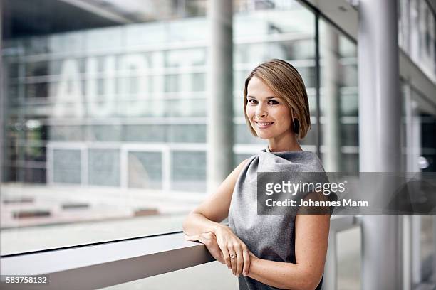 businesswoman leaning on a railing - portrait mann business stock pictures, royalty-free photos & images