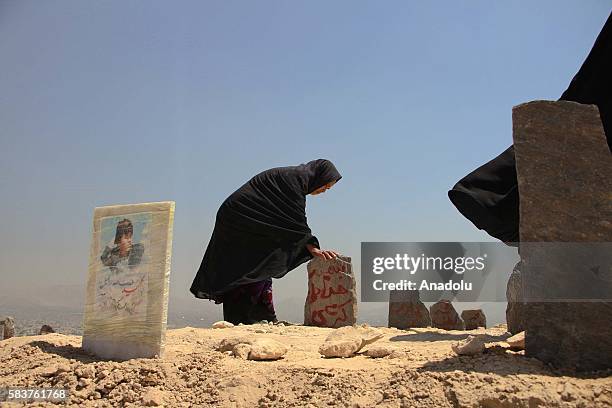 Afghan Shiite women visit their graves of their relatives, killed by suicide attack on Shia Hazara minority demonstration on Saturday, in Kabul,...