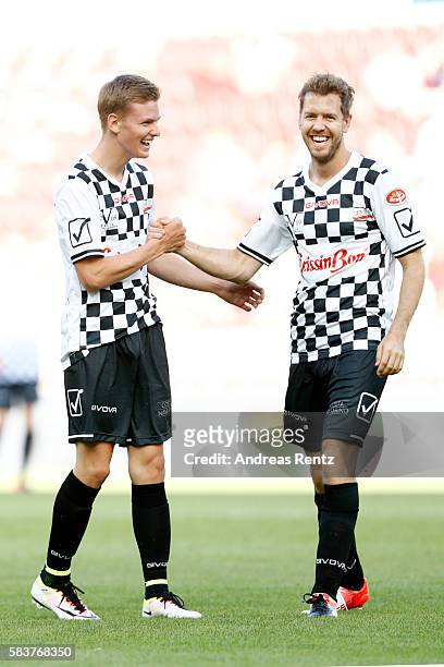 Mick Schumacher, son of Michael Schumacher, greets Sebastian Vettel during the 'Champions for charity' football match between Nowitzki All Stars and...