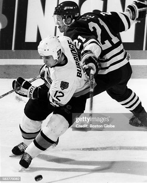 Boston Bruins player Randy Burridge, left, and Hartford Whalers player Sylvain Cote, right, collide during a division semi-final game at the Boston...